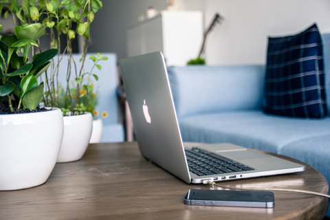 Laptop and mobile on living room coffee table