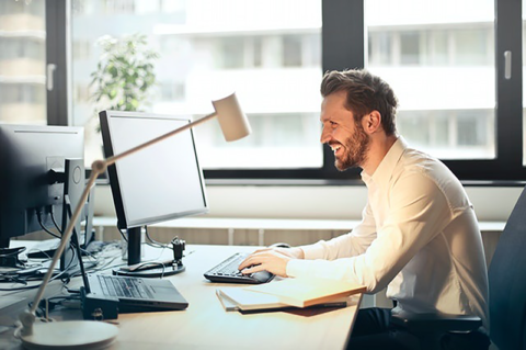 Smiling employee using his computer