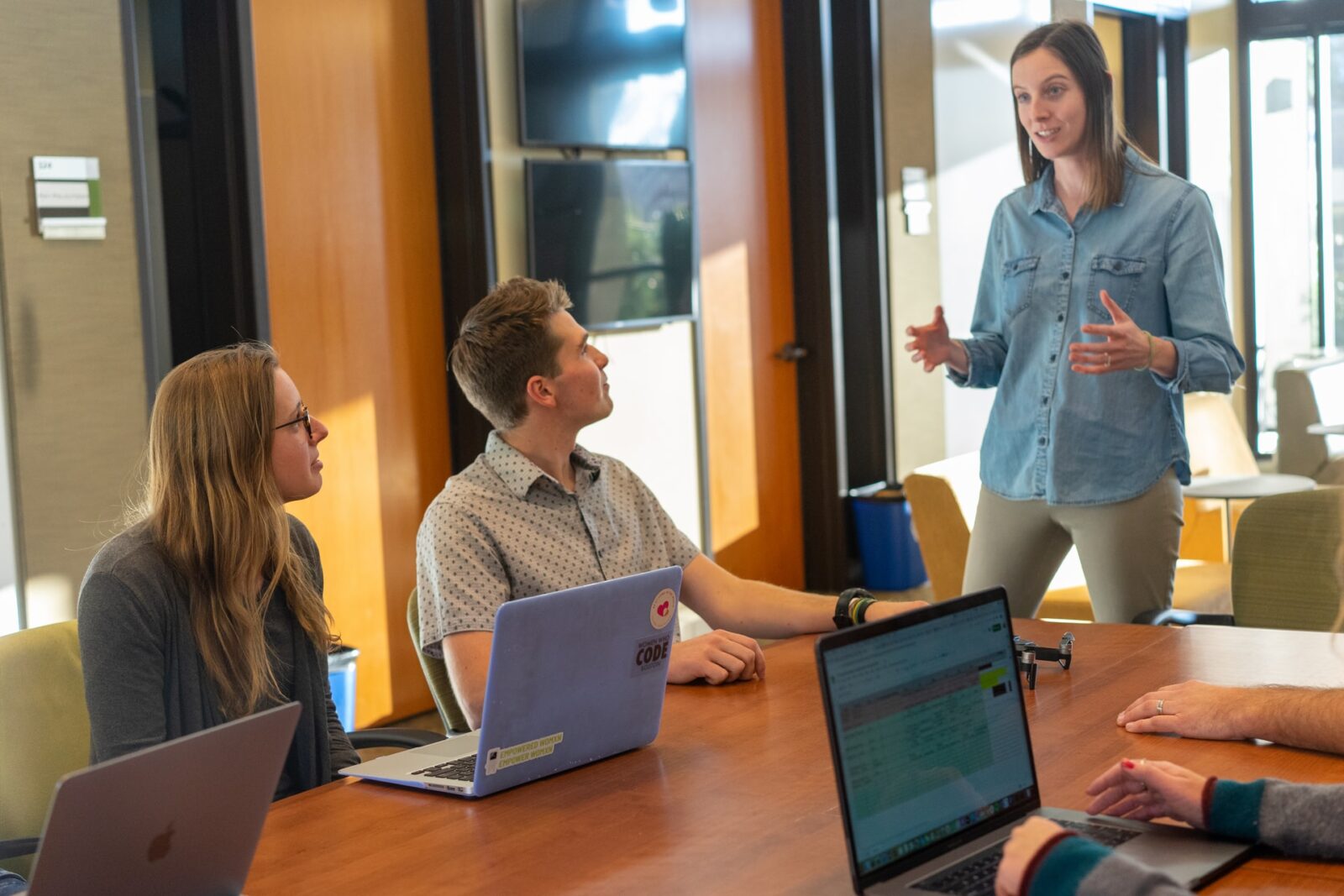 2 employees listening to another employee