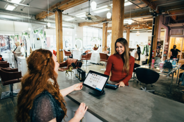 two women speaking to each other with a tablet